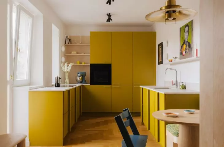 The mustard-colored kitchen is one of the boldest design elements in the entire apartment. The color makes a bold statement here, but it doesn't detract from the interior's airiness
