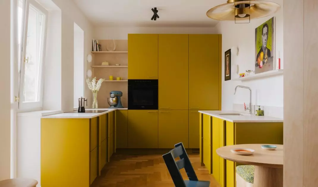 The mustard-colored kitchen is one of the boldest design elements in the entire apartment. The color makes a bold statement here, but it doesn't detract from the interior's airiness