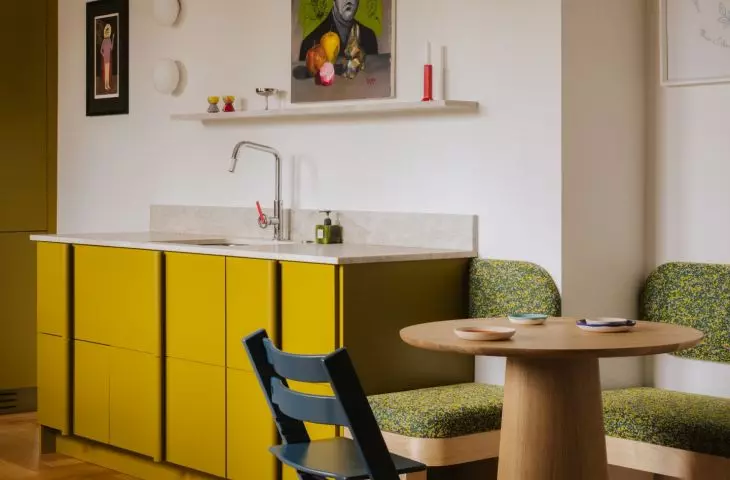 Soft lines, wood, and patterned fabric soften the kitchen's intense color