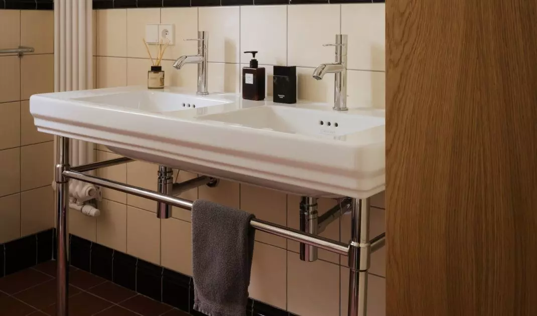 In this bathroom, the retro style isn't literal, but it's very palpable—in the rhythm of the tiles, the contrasts, and the combination of ceramic and wood