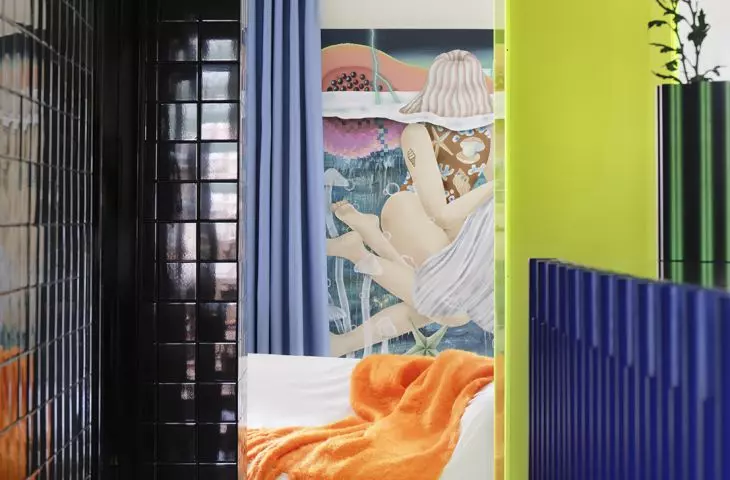 The neon acrylic marks the entrance to the bedroom and foreshadows the vibrant character of the entire apartment
