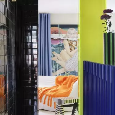 The neon acrylic marks the entrance to the bedroom and foreshadows the vibrant character of the entire apartment