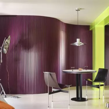 The eggplant-colored wall gives the dining room a theatrical feel and creates a striking backdrop for the table