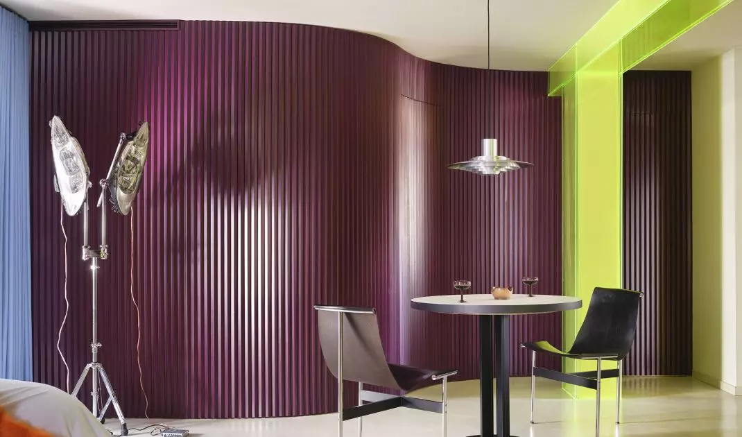 The eggplant-colored wall gives the dining room a theatrical feel and creates a striking backdrop for the table
