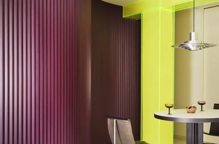 The curved, eggplant-colored wall guides the eye through the interior and softens its divisions