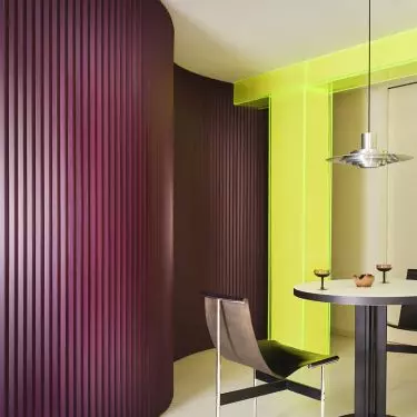The curved, eggplant-colored wall guides the eye through the interior and softens its divisions