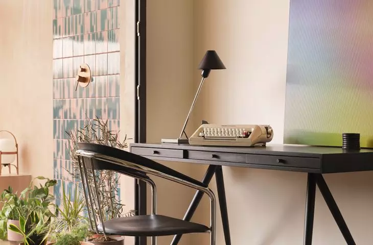 The home office opens onto a terrace, where the colors give way to warmer tones and greenery