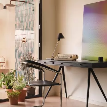 The home office opens onto a terrace, where the colors give way to warmer tones and greenery