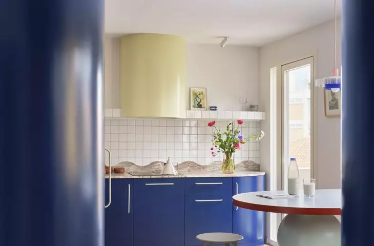 The kitchen remains functional, but thanks to its bold color and rounded shapes, it doesn't lose any of its character