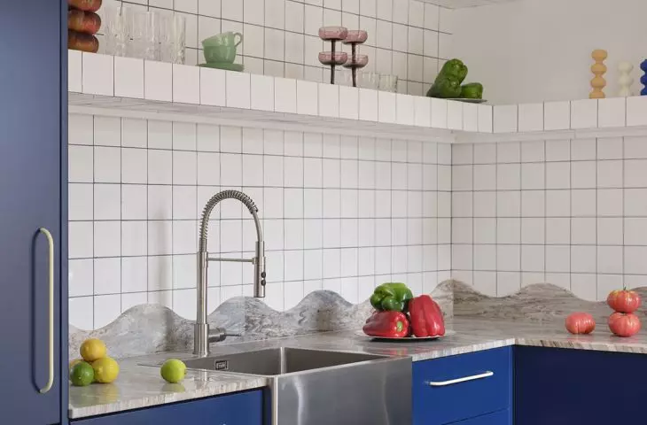 Open shelves, colorful glassware, and decorative knickknacks give the kitchen a more relaxed, homey feel