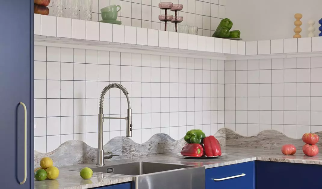 Open shelves, colorful glassware, and decorative knickknacks give the kitchen a more relaxed, homey feel
