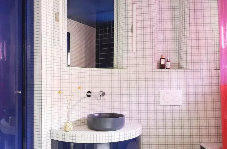 The rounded shapes and delicate mosaic make the bathroom feel like a separate room bathed in color.