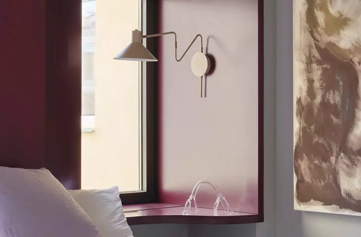 The bedroom is more serene, but it still features color, art, and soft textures.