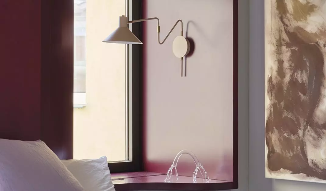 The bedroom is more serene, but it still features color, art, and soft textures.