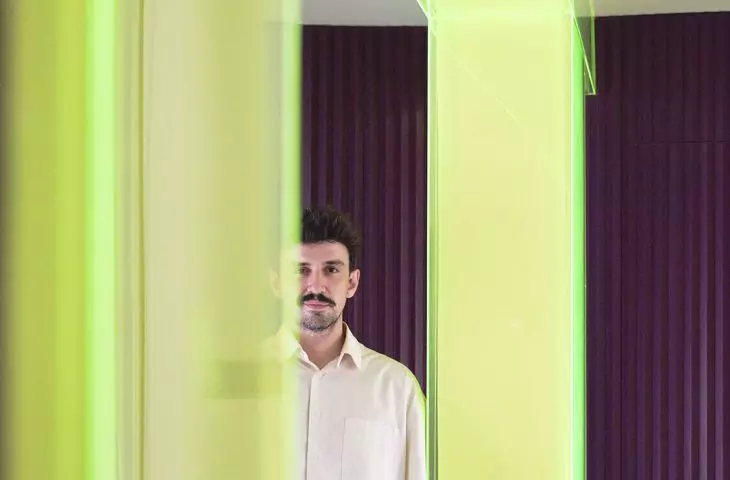 The neon frame has become one of the most recognizable elements of the design—it simultaneously divides the space, filters the light, and sets the mood of the interior