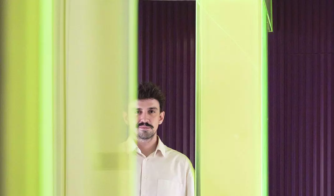 The neon frame has become one of the most recognizable elements of the design—it simultaneously divides the space, filters the light, and sets the mood of the interior