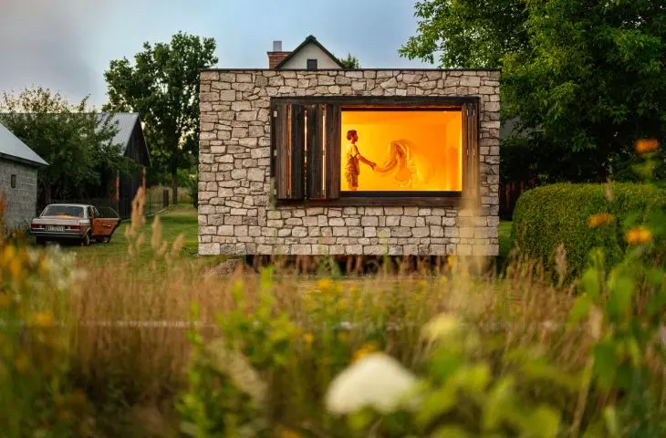 The stone gives the building a simple, austere form, while the glass openings open it up to the garden