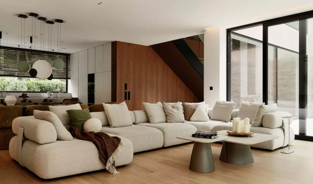 A soft, modular sofa and large windows create a serene atmosphere in the living room, which opens onto the garden