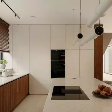 The kitchen embraces elegant minimalism: light-colored cabinetry, wooden cabinet fronts, and a stone countertop