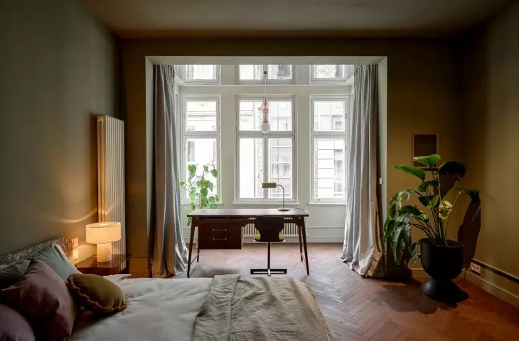 In the bedroom, light and softness are the most important elements. The bed is placed against a subdued green wall, and the bay window has been transformed into a peaceful workspace overlooking the center of Wrocław