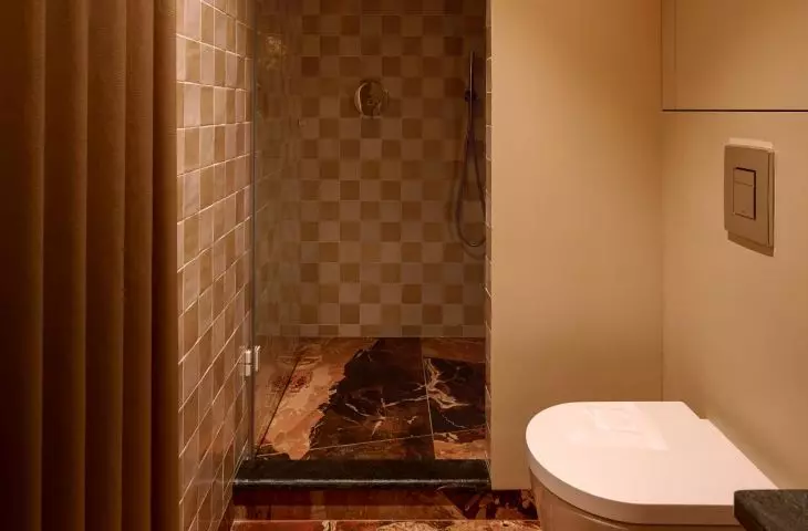 The bathroom features a warm, subdued color palette.