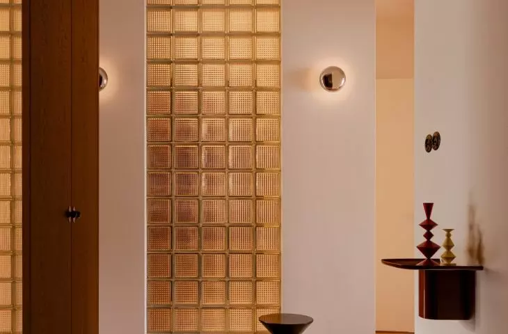 Glass blocks, a checkerboard pattern, and dark woodwork create a strong first impression upon entering the apartment