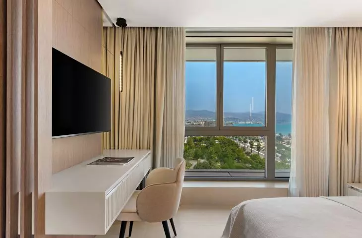 Large windows open up the interior to views of the city, the harbor, and the Mediterranean Sea