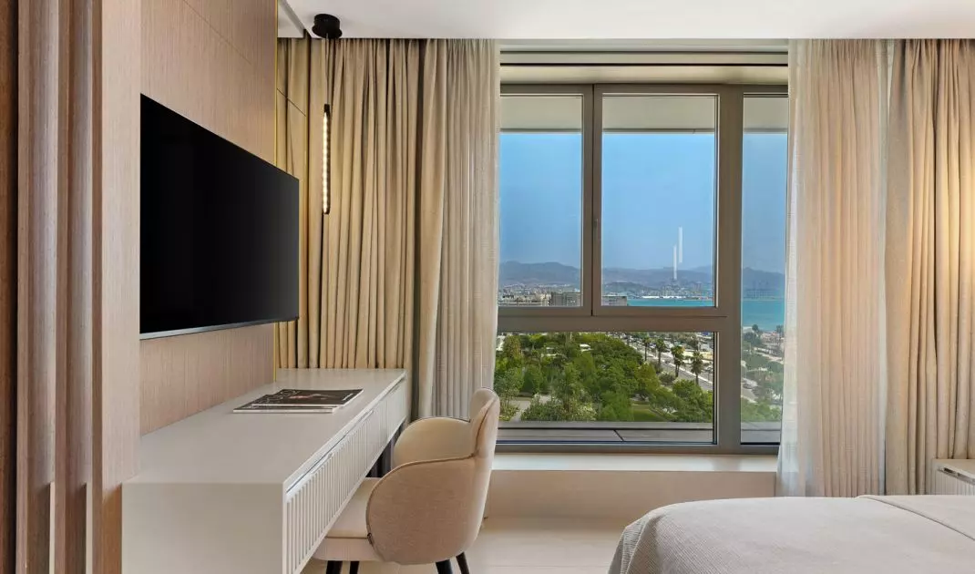 Large windows open up the interior to views of the city, the harbor, and the Mediterranean Sea