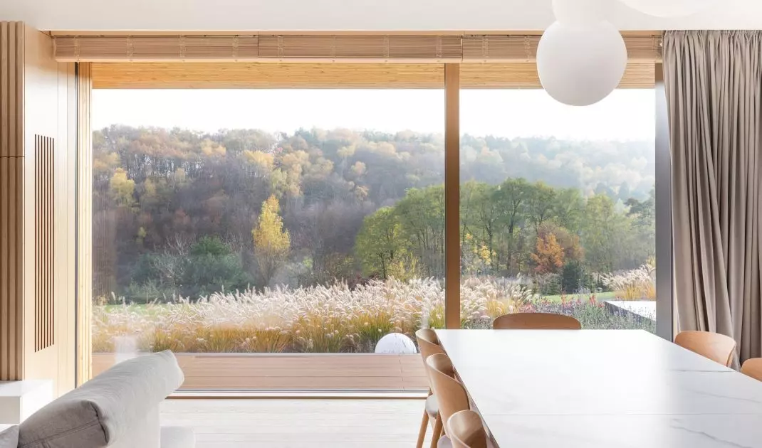 Panoramiczne przeszklenie w jadalni Forrest View House kadruje widok na Las Michałowicki, który zmienia się wraz z porami roku