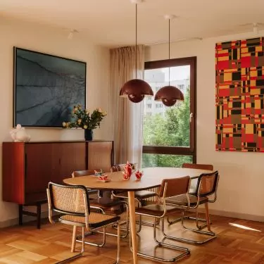 In the dining room, vintage furniture serves as a backdrop for works from the owners' collection