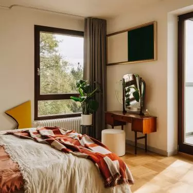 This Wrocław apartment, designed by Buduar, combines art, vintage furniture, and warm, bold colors