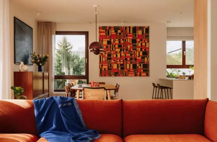 This Wrocław apartment, designed by Buduar, combines art, vintage furniture, and warm, bold colors