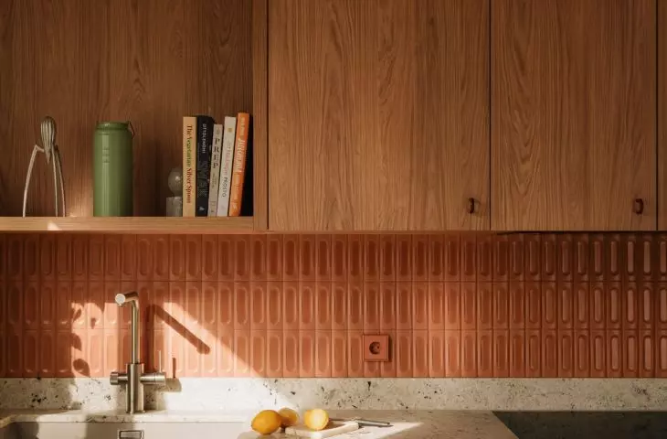 The warm wooden cabinetry is complemented by colorful tiles and a stone countertop