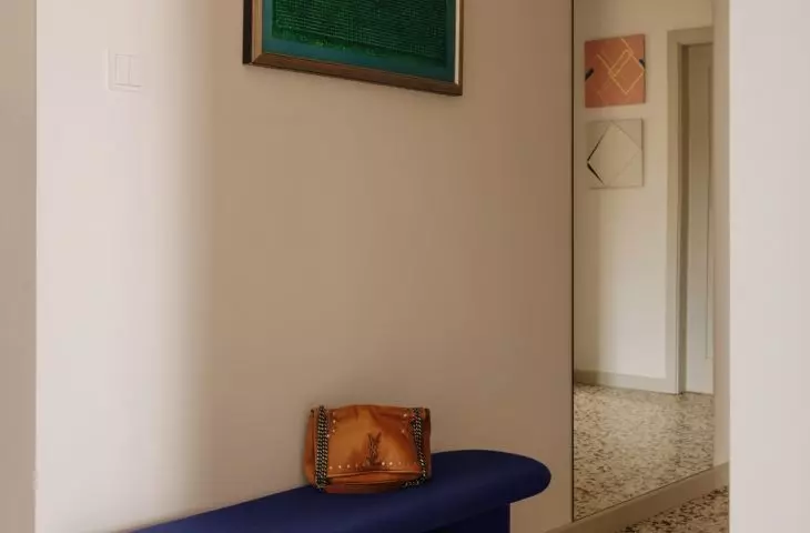 The cobalt-blue bench adds a bold accent to the entryway