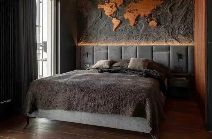 The dimly lit bedroom, with a map on the wall, reflects the owner's passion for travel