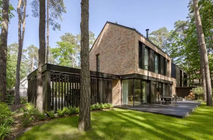 The floor-to-ceiling windows on the ground floor connect the living area with the terrace and the pine garden