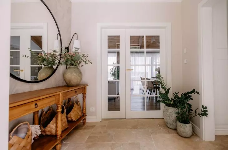 The bright entryway with travertine flooring sets the tone for the natural color palette of the entire interior