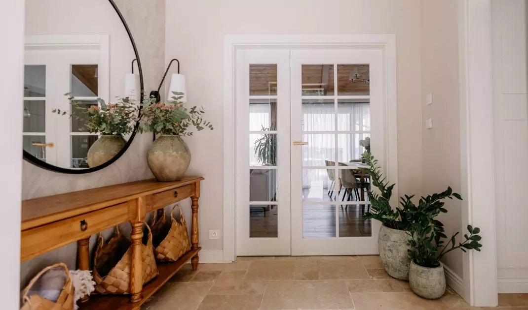 The bright entryway with travertine flooring sets the tone for the natural color palette of the entire interior