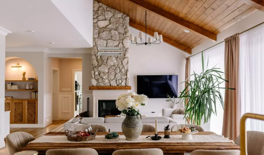 A wooden table defines the dining area, which seamlessly connects the kitchen to the living area