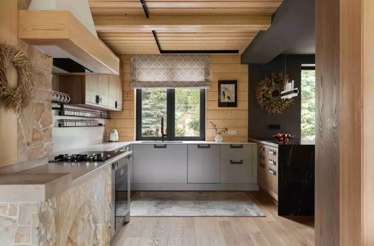 In the kitchen, gray cabinet fronts are paired with natural wood and stone