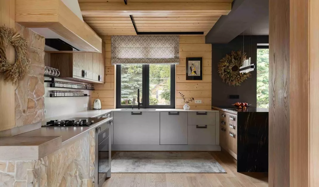 In the kitchen, gray cabinet fronts are paired with natural wood and stone