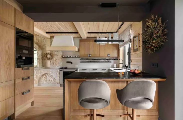 The wooden cabinetry gives the kitchen a warmer feel, and the open layout connects it to the rest of the living area