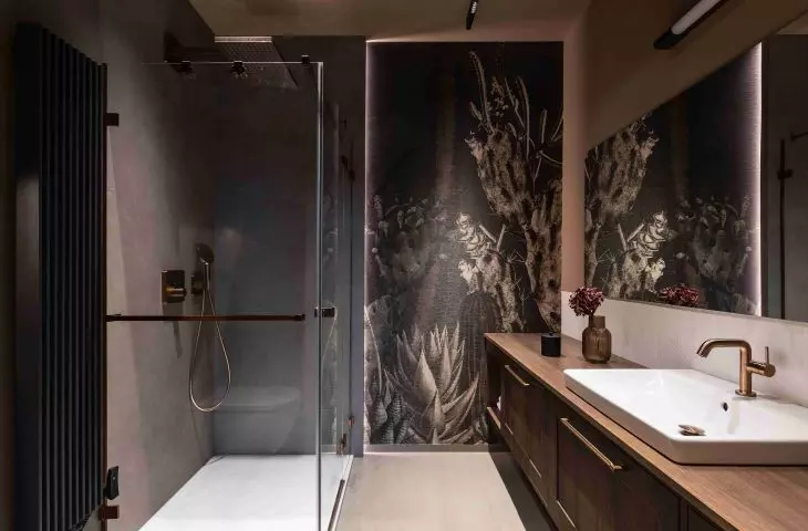 In one of the bathrooms, the calm atmosphere is broken up by dark wallpaper with a floral pattern 