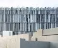 Warstwowa fasada muzeum została ukształtowana z pionowych aluminiowych profili o różnej długości i rytmie