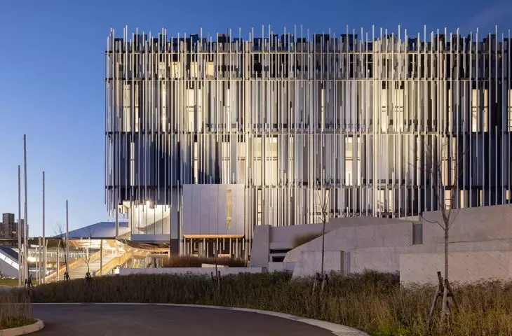 The museum’s illuminated facade highlights the lightness of the vertical elements that envelop the monumental structure