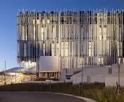 The museum’s illuminated facade highlights the lightness of the vertical elements that envelop the monumental structure