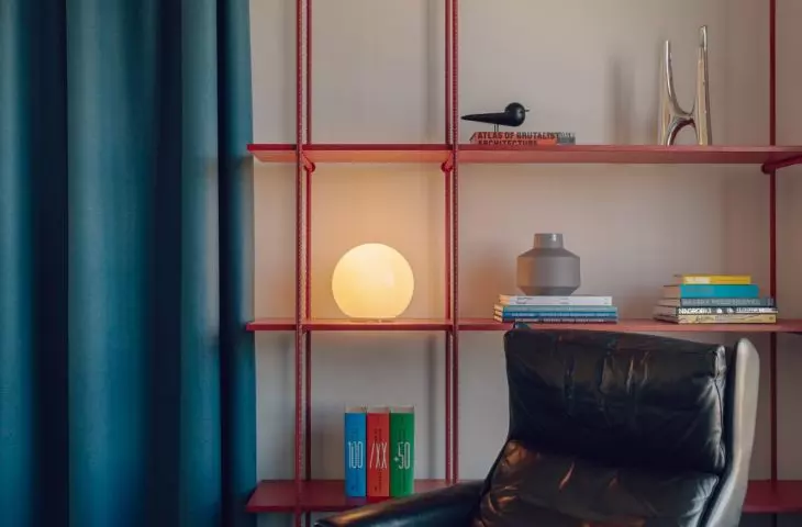 The custom-made red bookcase and leather armchair give the lounge area a distinctive character