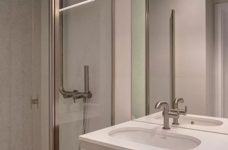 The light color scheme and large mirror make the bathroom, which lacks natural light, appear brighter