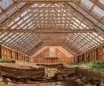 A wooden structure shelters the preserved remains of a Viking-era farmstead