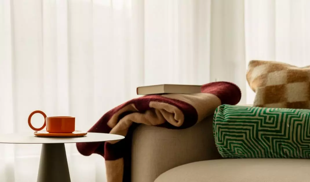 Zaokrąglona sofa podkreśla miękki język form obecny w całym mieszkaniu